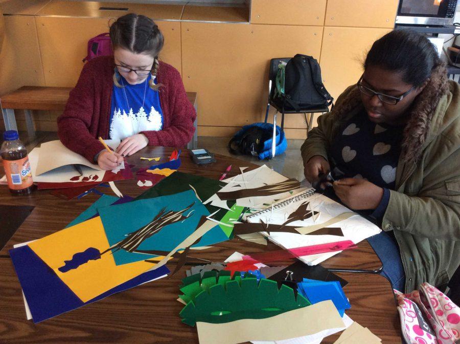 Students prepare their art gallery compositions. This year, students were given a variety of colored window clings that they were asked to cut and shape into stained glass style representations.