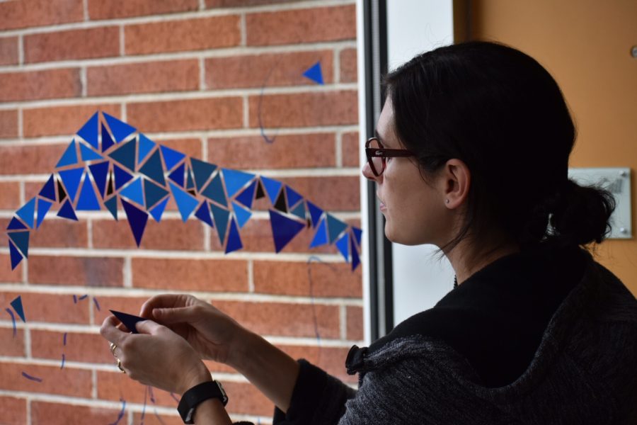 A member of the faculty works on her window design. Prep artists made their window pieces under the theme of animals. 
