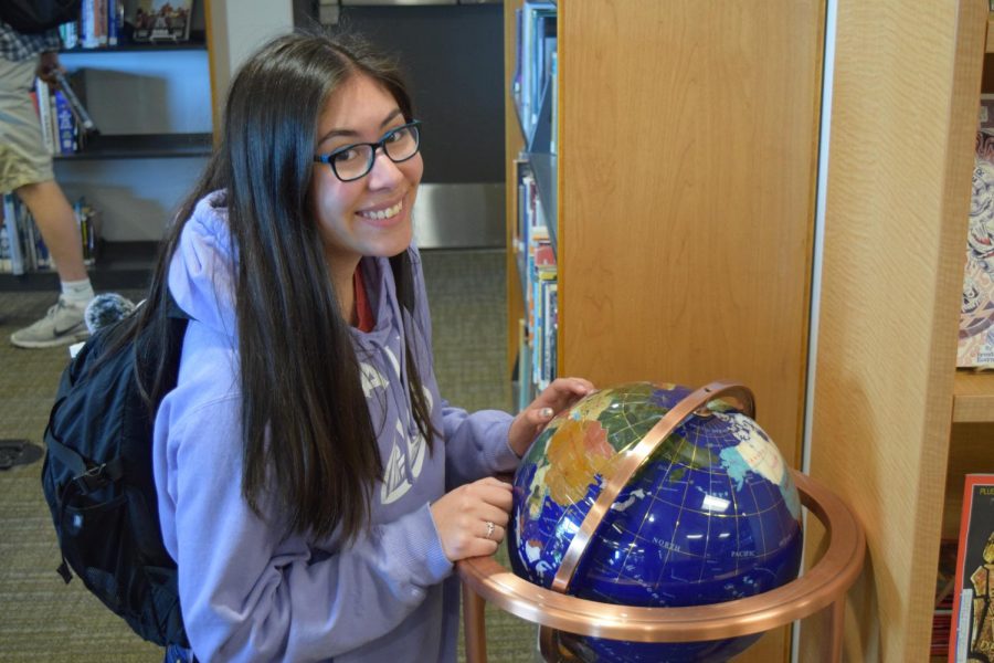 Ganz poses with a globe as she sets sights for her future voyages during her gap year.