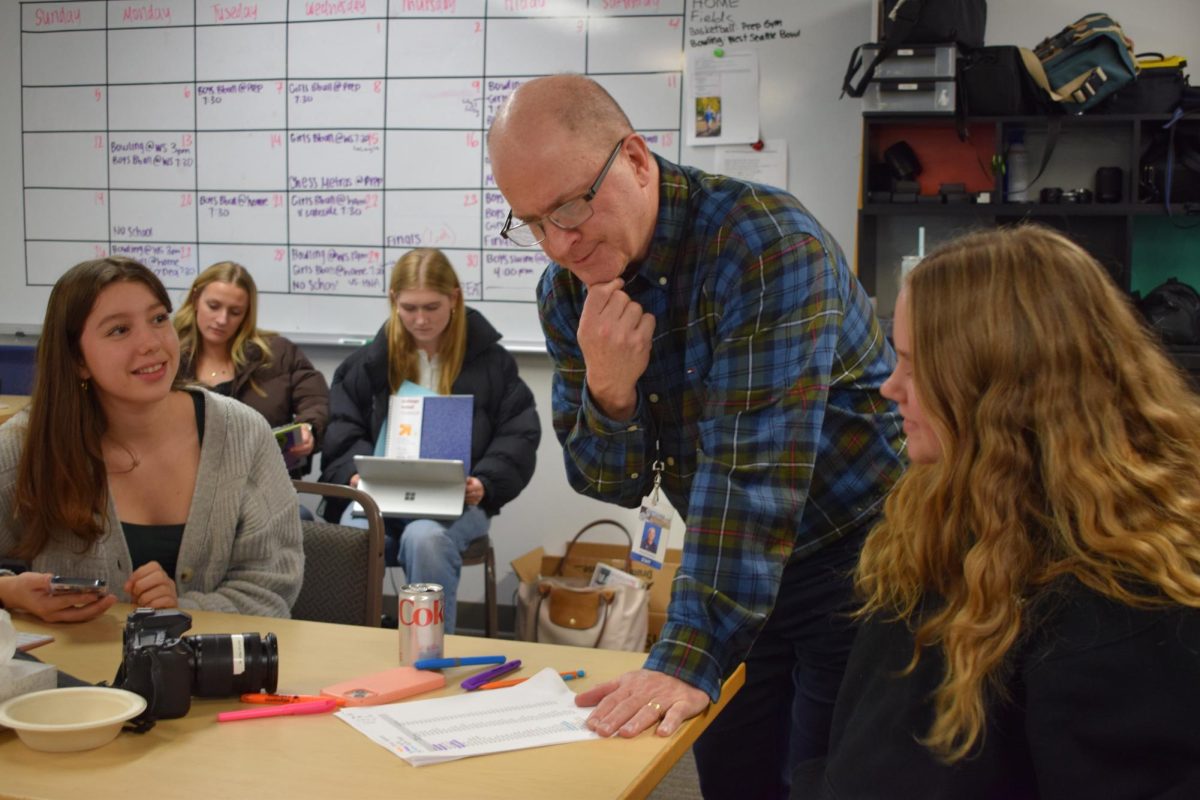 Mr. Danielson works with two yearbook staff members during a Window work period.