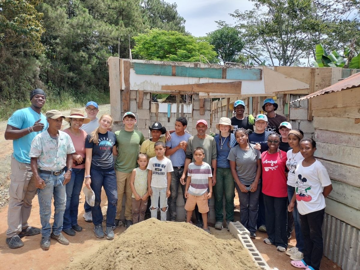 Prep students pose with Dominican families in Franco Bidó, where they helped build houses and plant trees.